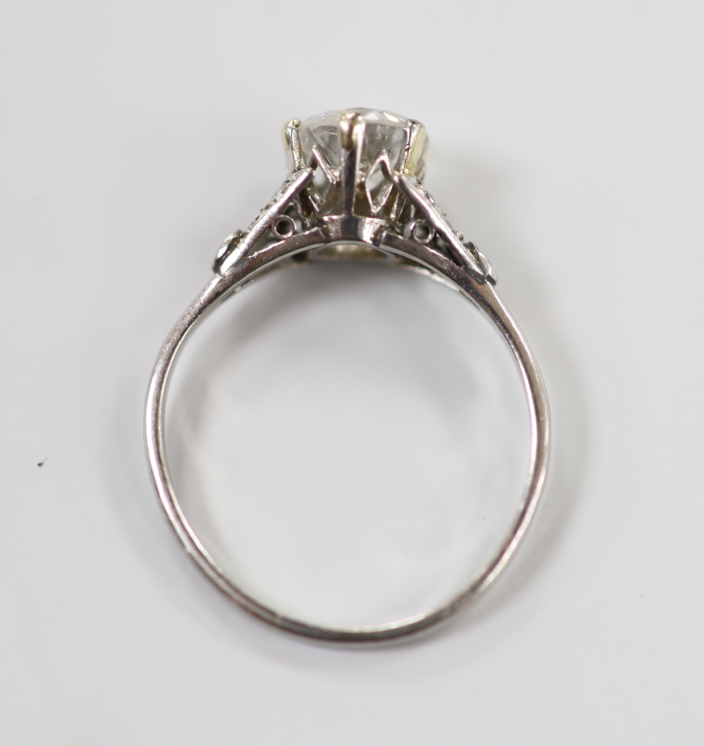 A white metal (stamped plat) and single stone diamond ring, with diamond chip set shoulders, size L/M, gross weight 2.4 grams